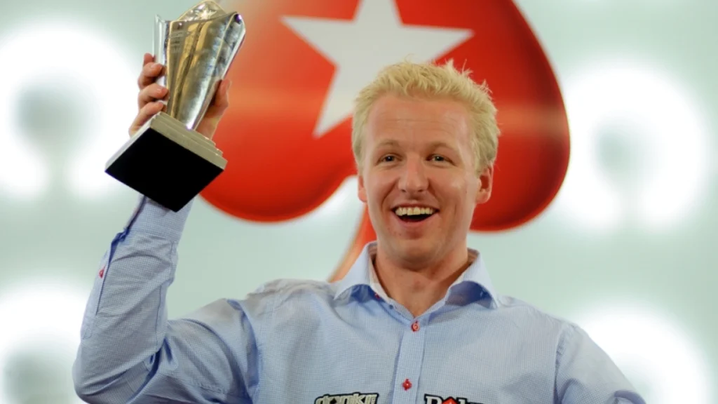 Allan Bække løfter et trofæ og fejrer sin sejr i en stor pokerturnering.