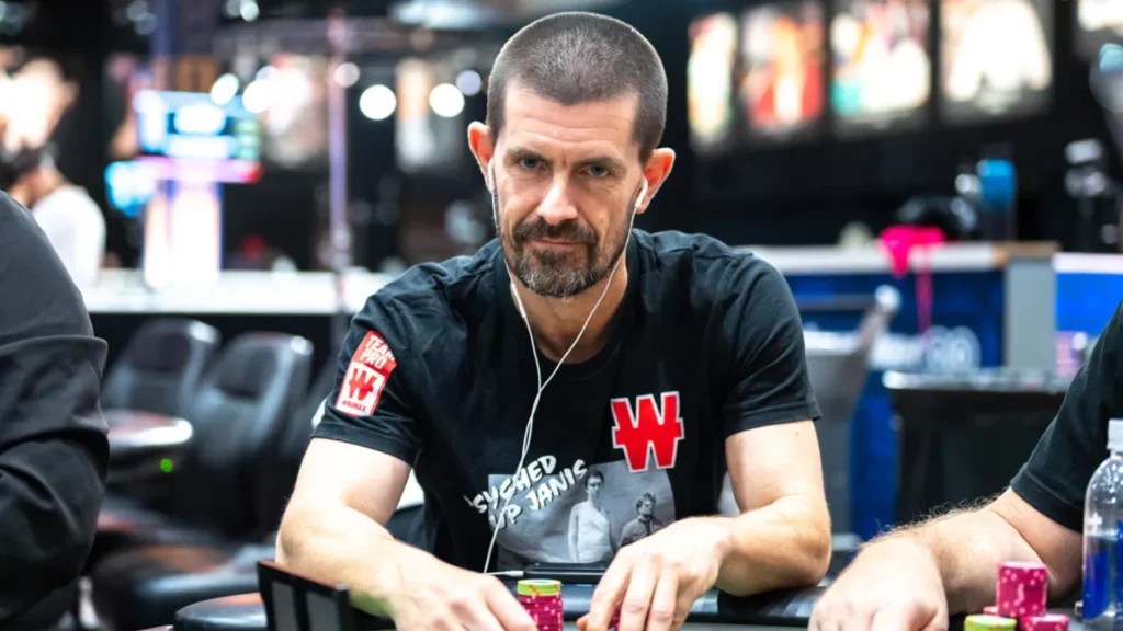 Gus Hansen sidder ved et pokerbord i et casino med chips foran sig under en pokersession.