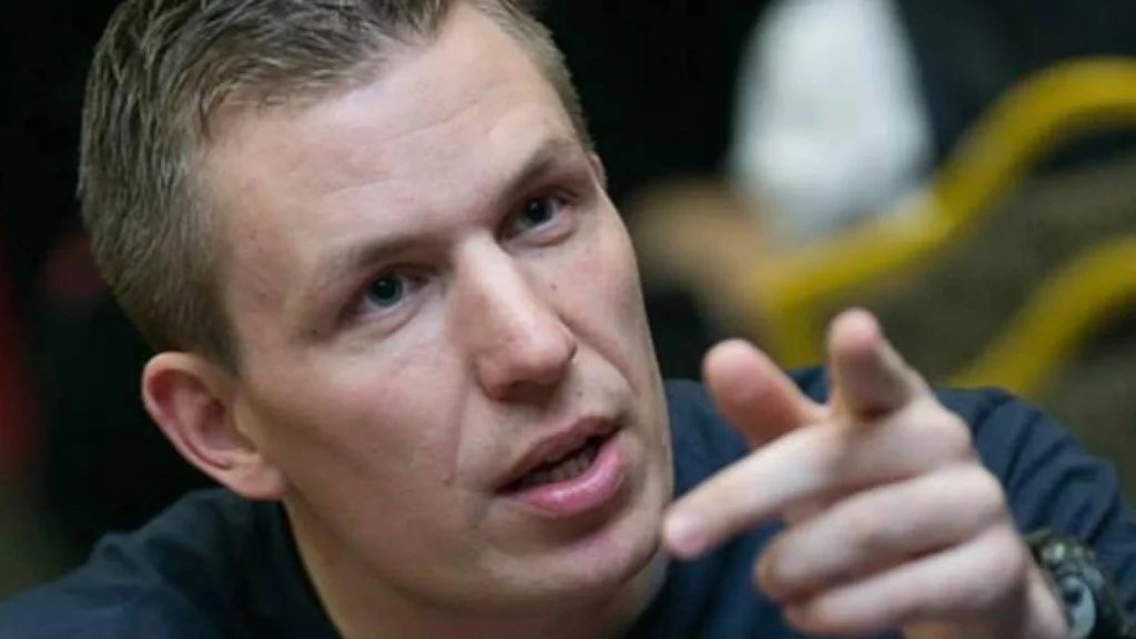 Jan Sørensen taler og peger under en pokerturnering ved bordet.