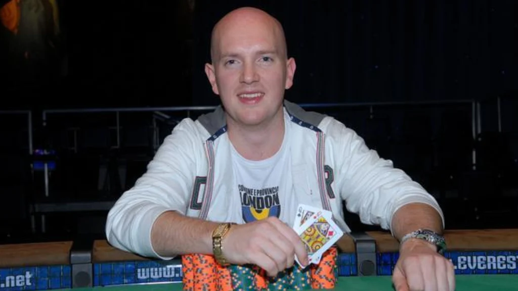 Jesper Hougaard sidder ved et pokerbord med chips og spillekort under en pokerturnering.