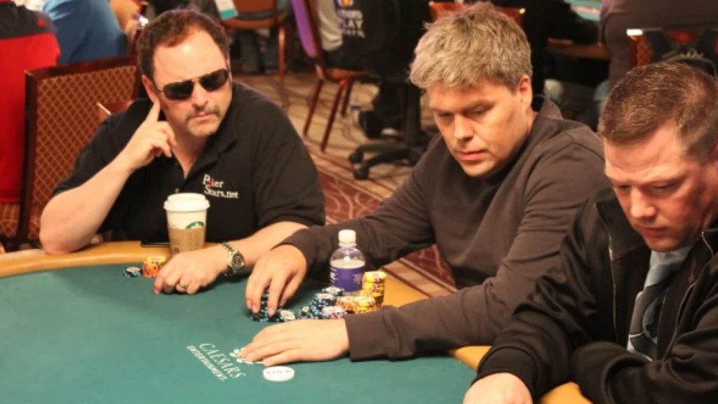 Mads Andersen spiller poker ved et bord med chips og kort under en turnering.