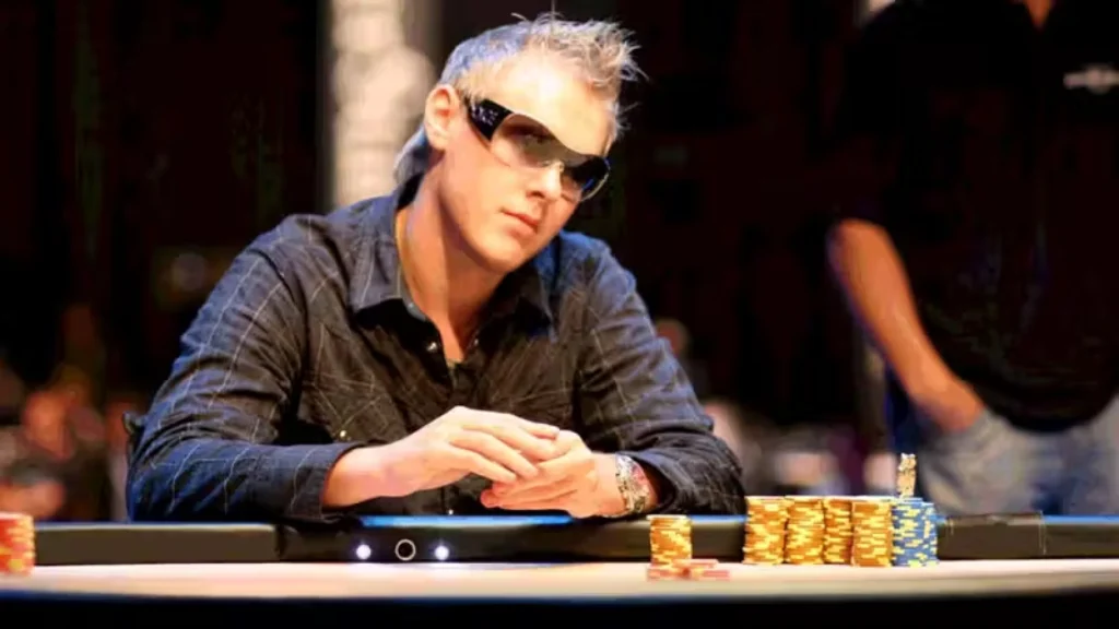 Søren Kongsgaard i solbriller spiller poker ved bordet med høje stakke chips foran sig