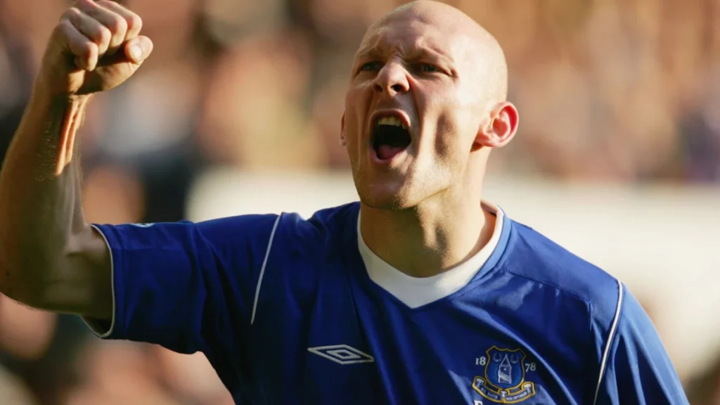 Thomas Gravesen jubler på fodboldbanen i Everton-trøje efter et mål under en kamp.
