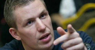 Jan Sørensen taler og peger under en pokerturnering ved bordet.