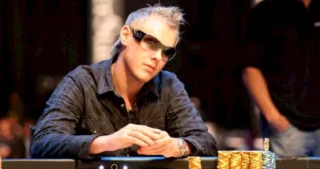 Søren Kongsgaard i solbriller spiller poker ved bordet med høje stakke chips foran sig