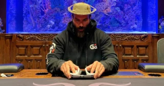 Thomas Gravesen sidder ved et pokerbord og holder kort, koncentreret under et pokerspil på casino.